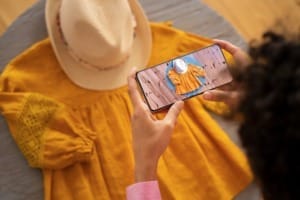 The image shows a woman taking photos to sell products on Instagram; it's an Instagram social media image.